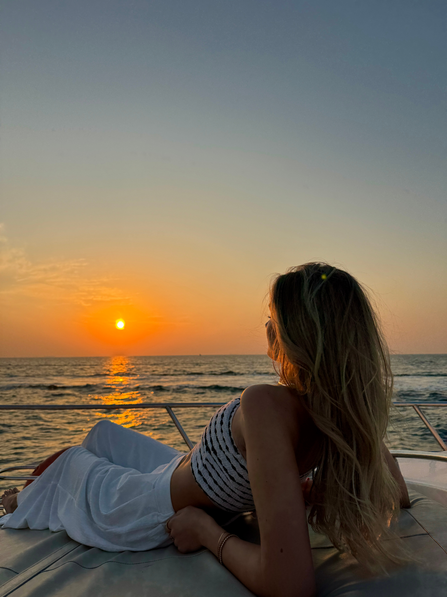 Alina watching the sunset from a boat